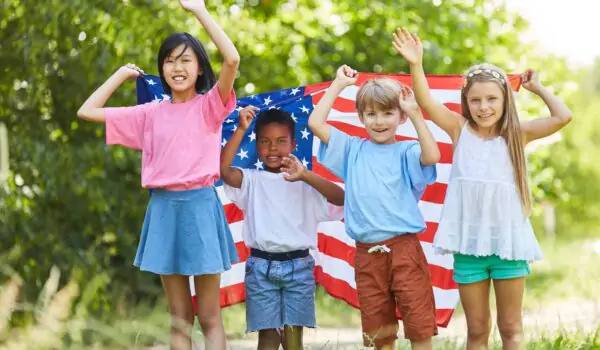 Multicultural group of kids waving with US flag on Labor Day