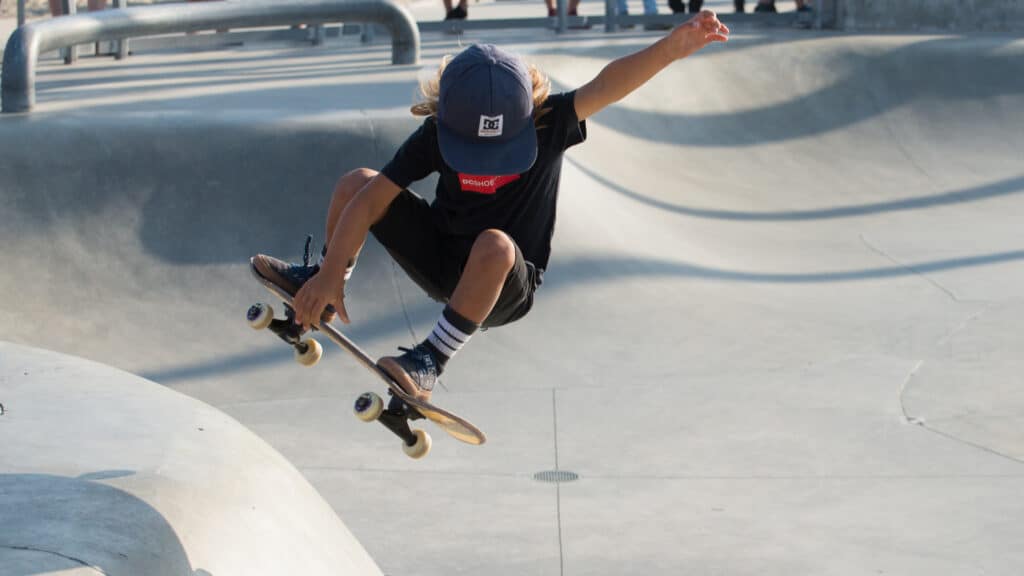Girl performing tricks at half pipe skateboarding in Santa Monica, Los Angeles