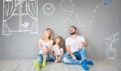 Happy family of trusted house sitters, sitting on wooden floor. Interior design concept on walls