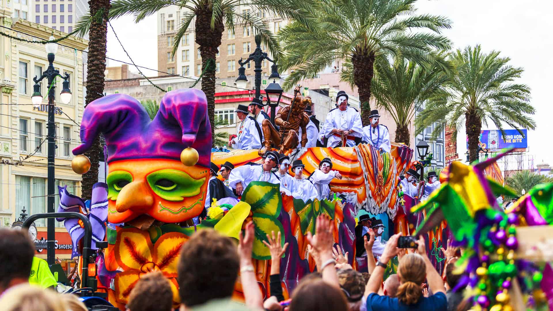 Mardi Gras parades through the streets of New Orleans with people cheering