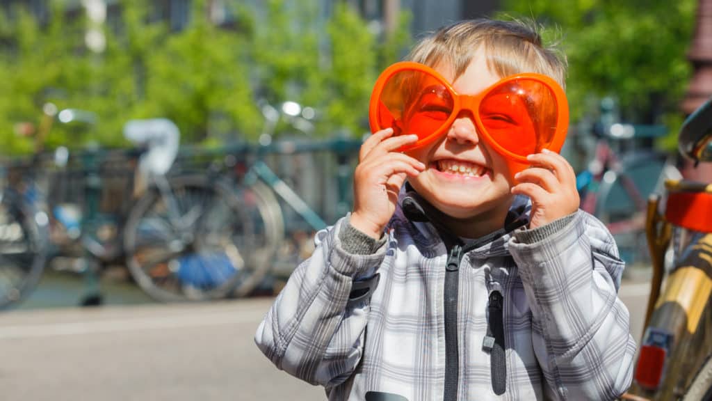Boy wearing orange glasses for fun in Amsterdam Netherlands