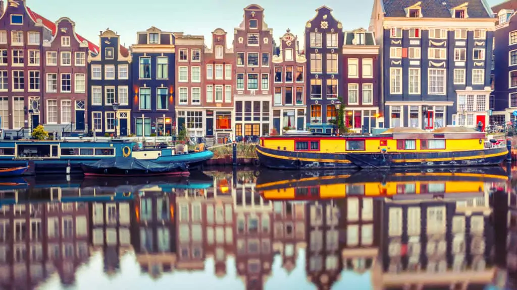Typical houses at Singel Canal in Amsterdam, Holland, Netherlands, with houseboats in front