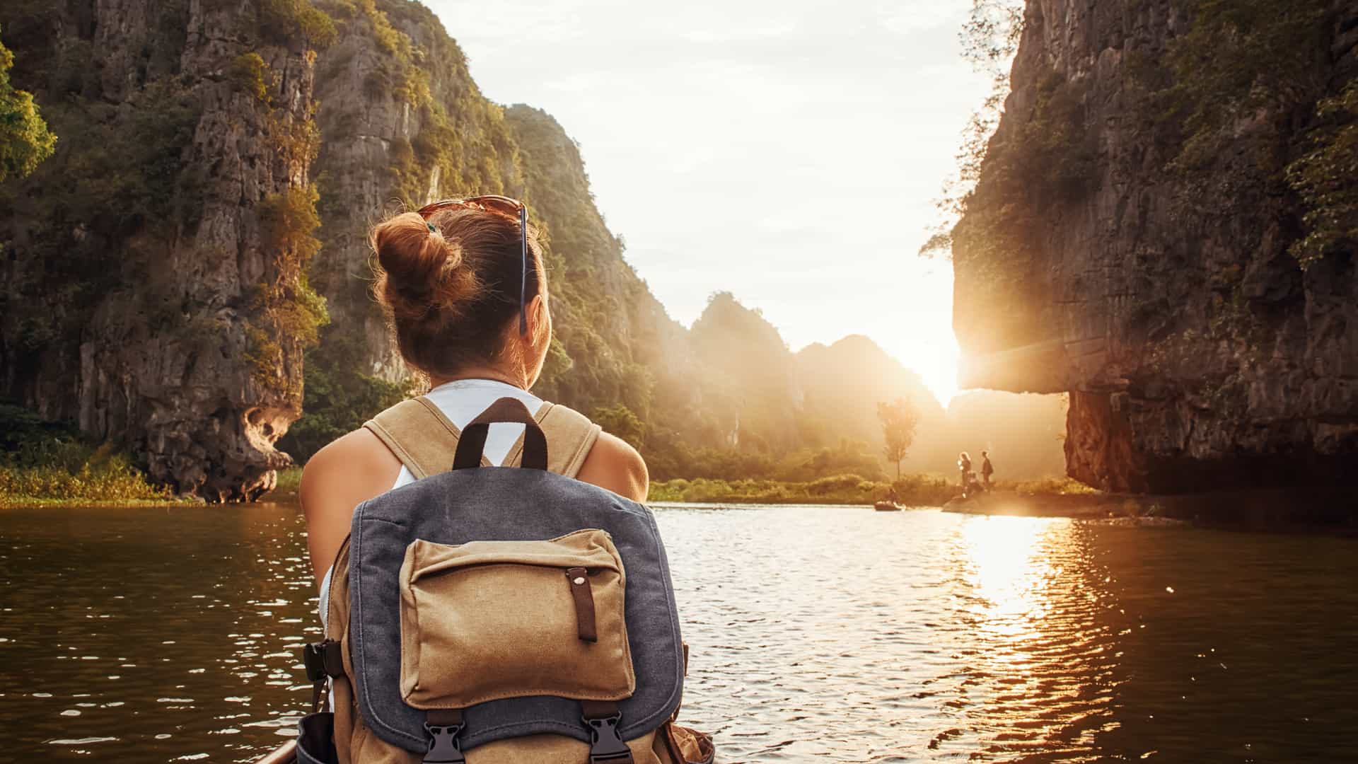 Girl with a carry-on backpack enjoying sunset in Halong Bay in Vietnam
