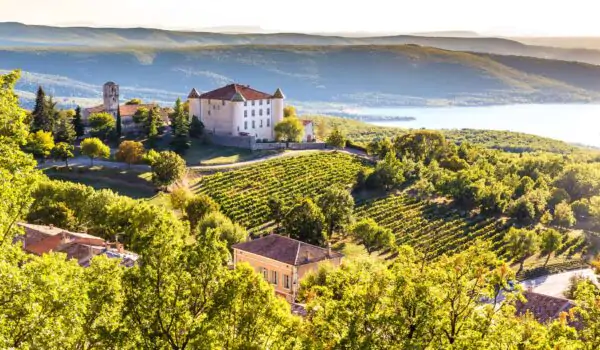 View of Village Aiguines and renaissance style chateau overlooking Lac de Sainte Croix Lake in Alpes de Haute Provence,France