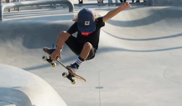 Girl performing tricks at half pipe skateboarding in Santa Monica, Los Angeles