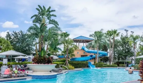 Family sitting near pool in waterpark with slides in USA