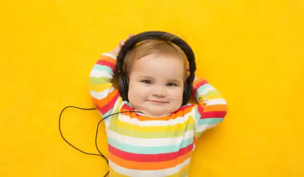 Baby equipped with headphones on a yellow background