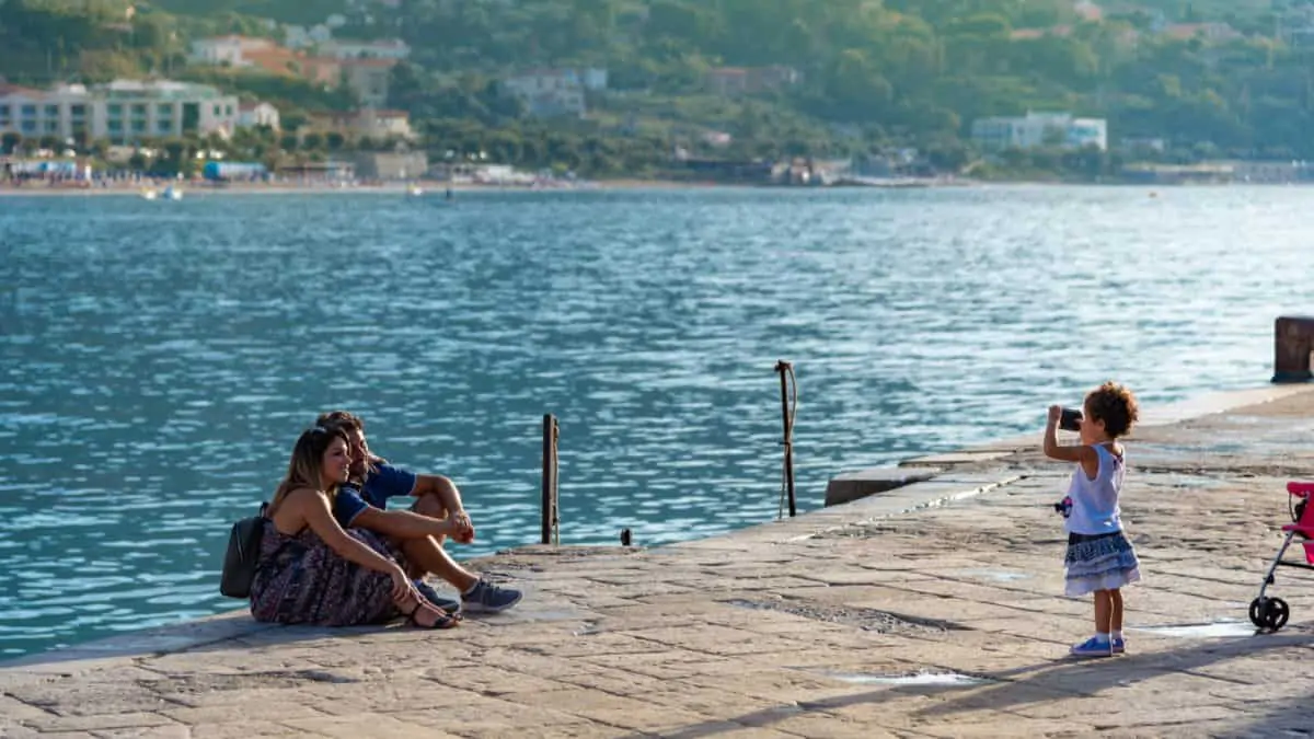 Happy and cute family in Cefalu Sicily, little girl taking picture