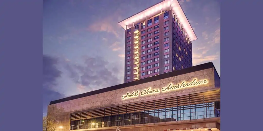 Exterior night view of the Hotel Okura Amsterdam with purple sky