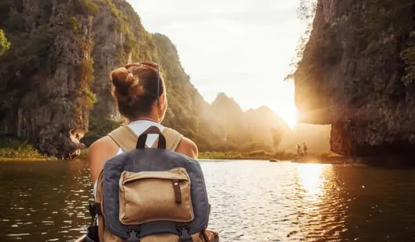 Girl with a carry-on backpack enjoying sunset in Halong Bay in Vietnam