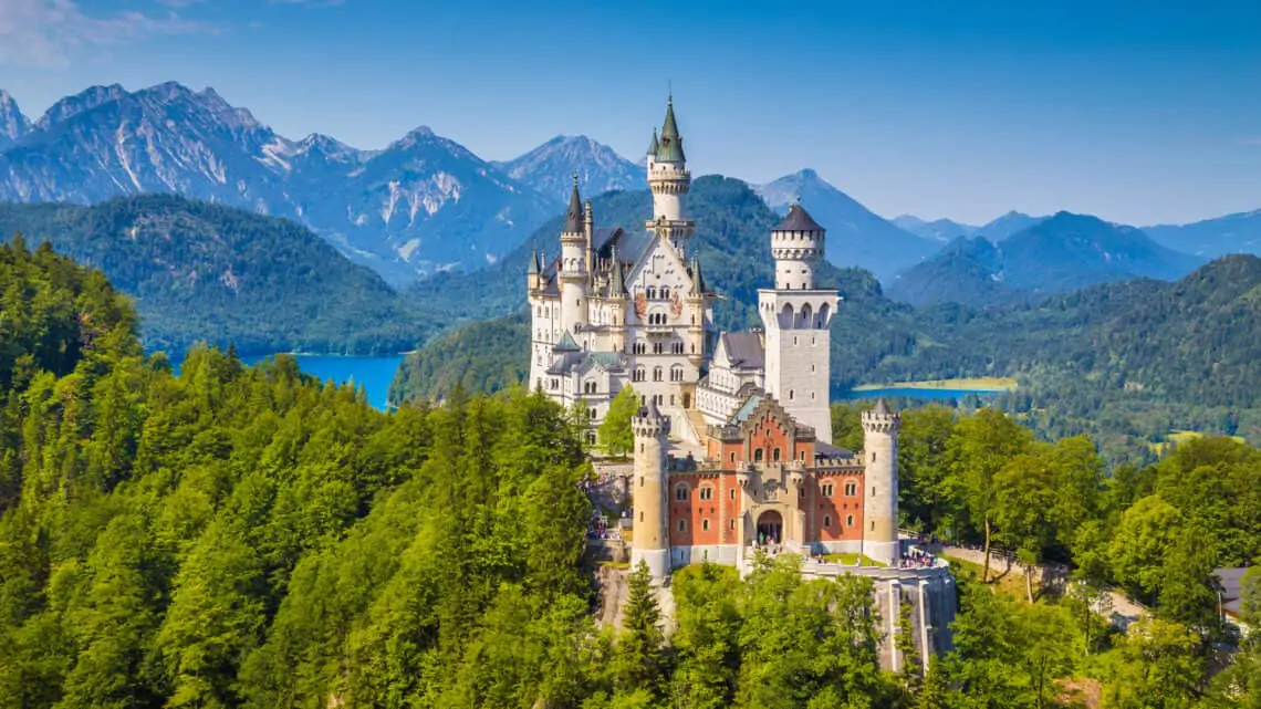 Aerial view of Schloss Castle Neuschwanstein in Fuessen Germany with lake and mountains in the background