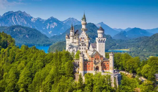 Aerial view of Schloss Castle Neuschwanstein in Fuessen Germany with lake and mountains in the background