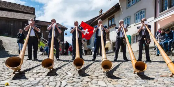 Swiss musicians play the alphorn in Gruyeres village, Switzerland