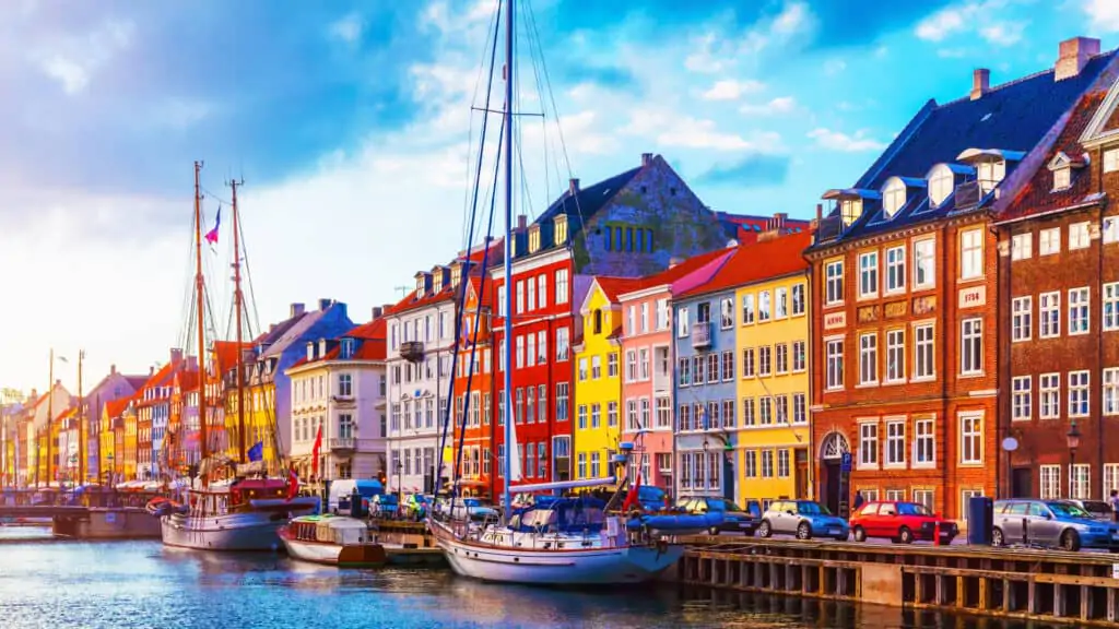 Summer sunset at Nyhavn pier in Copenhagen, Denmark with boats